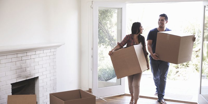 A young couple moving boxes into their new home